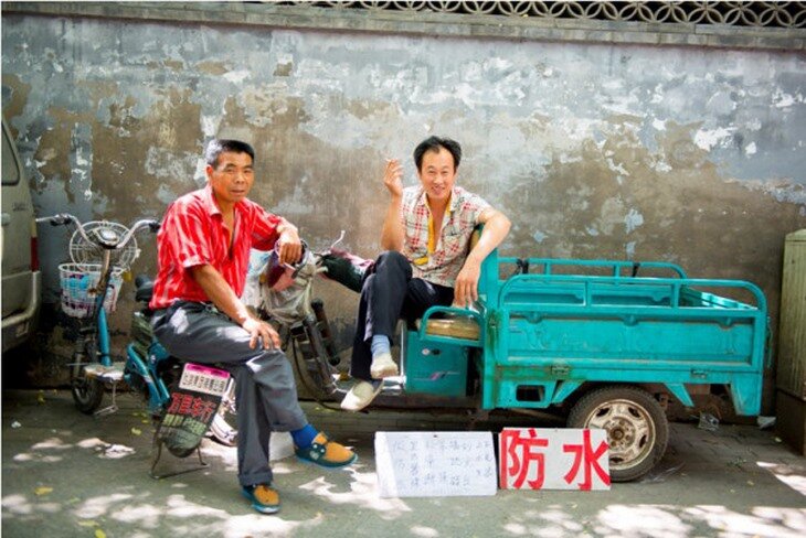 China: dos trabajadores descansando en la calle