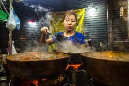 Mujer tailandesa cocinando comida callejera en Tailandia